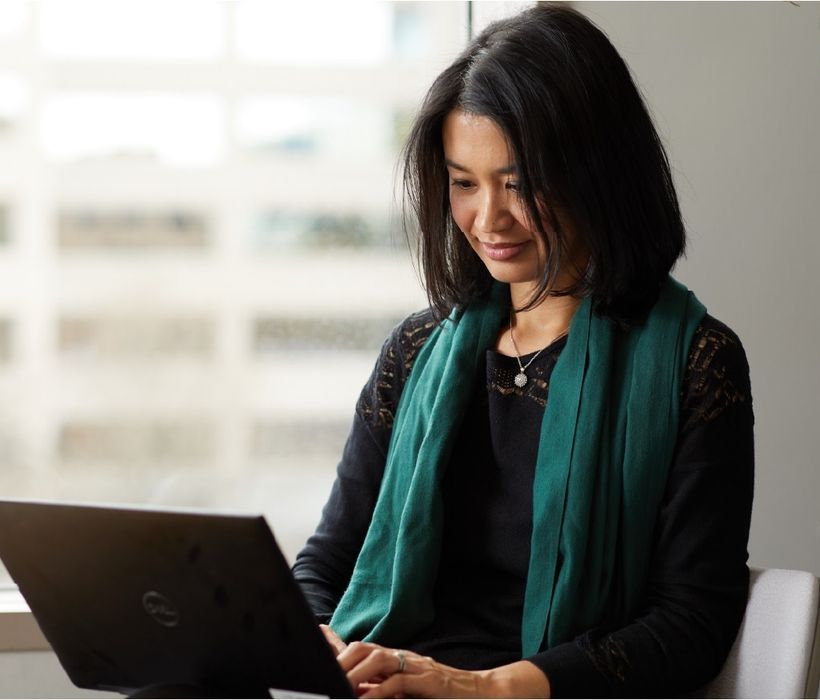 Person sitting by a window on a laptop